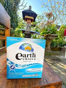 Earth Choice ultra concentrate laundry detergent on wooden bench in tropical Balinese garden with traditional shrine in background